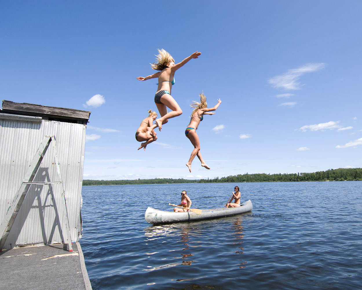 Girls lake jump by Winnipeg editorial photographer